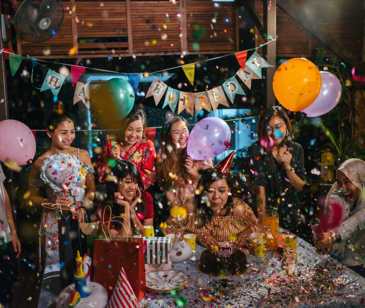 Birthday celebration with balloons and confetti.