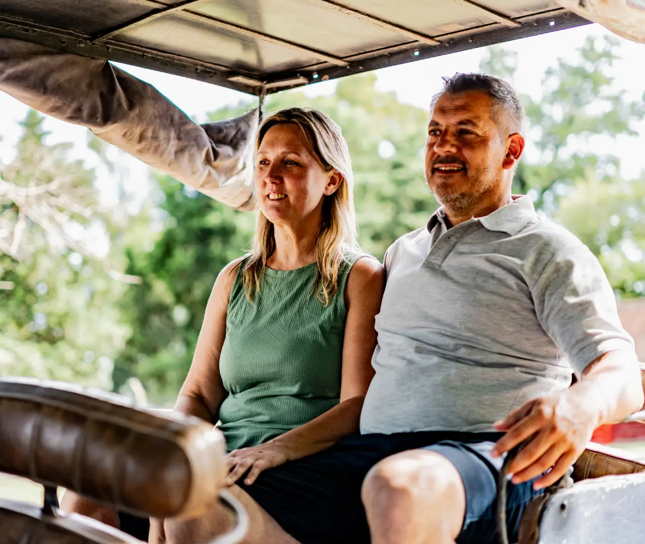 Couple sitting in an open-air vehicle.