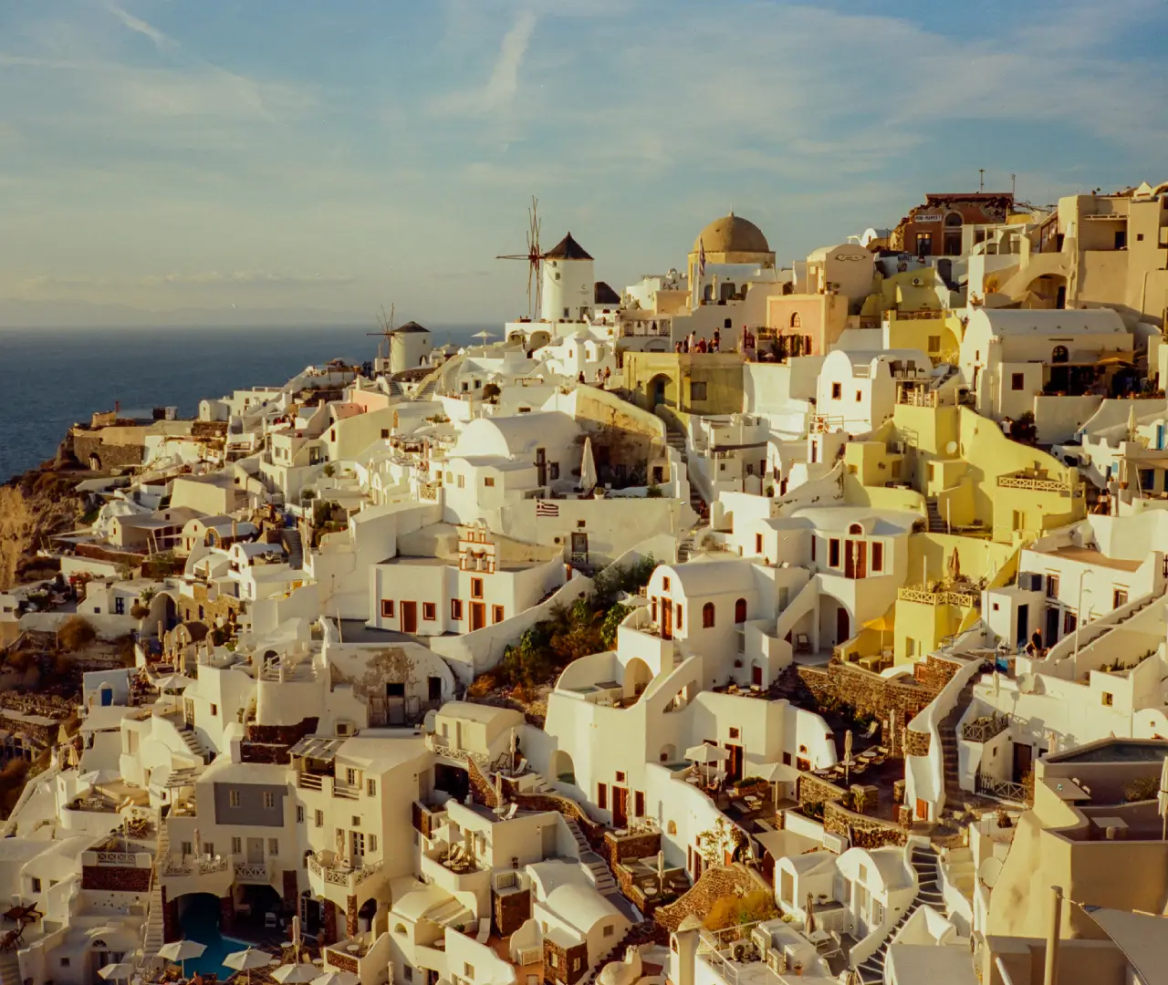 Santorini village with white and pastel buildings.