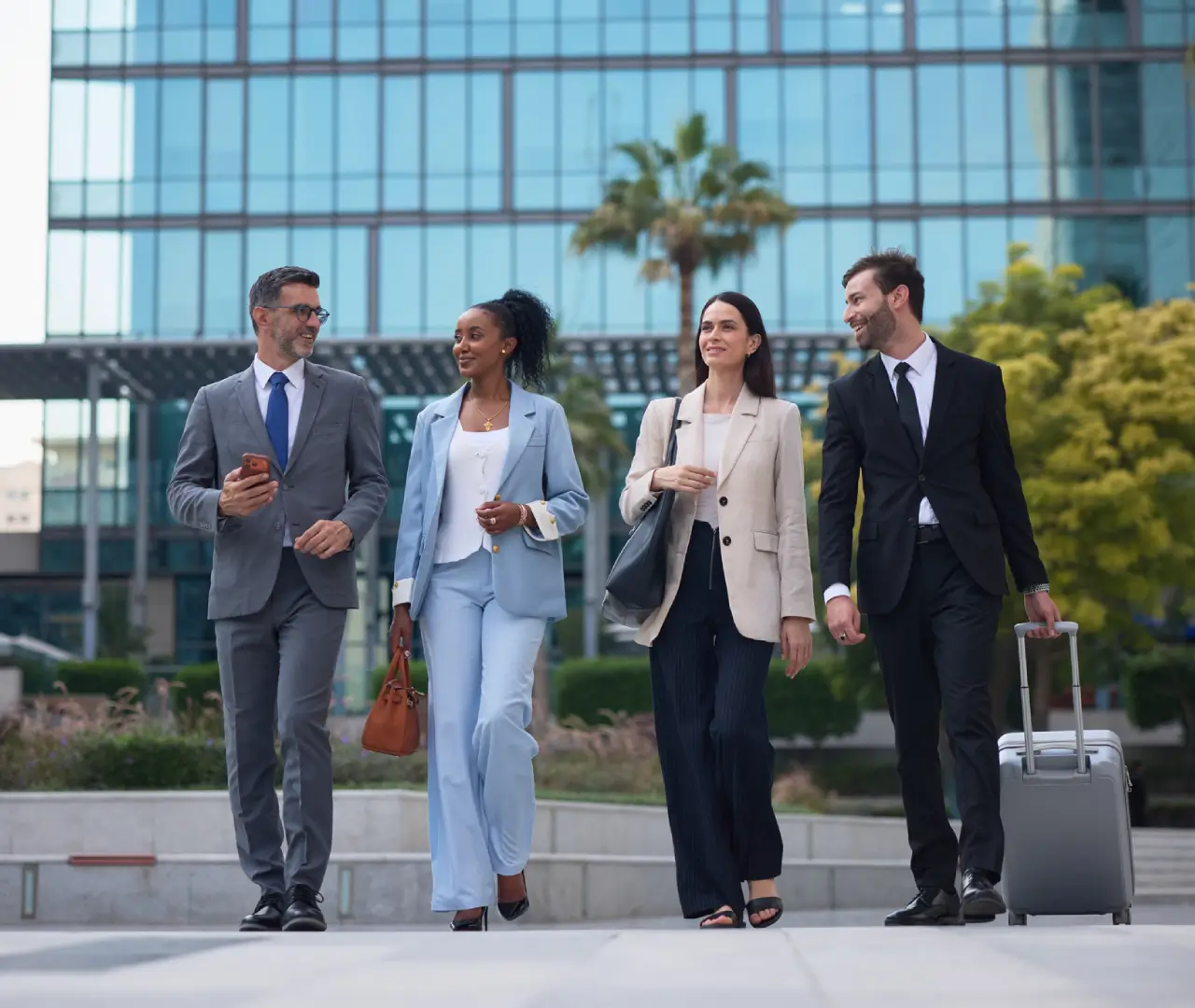 Business professionals walking outside modern office building.