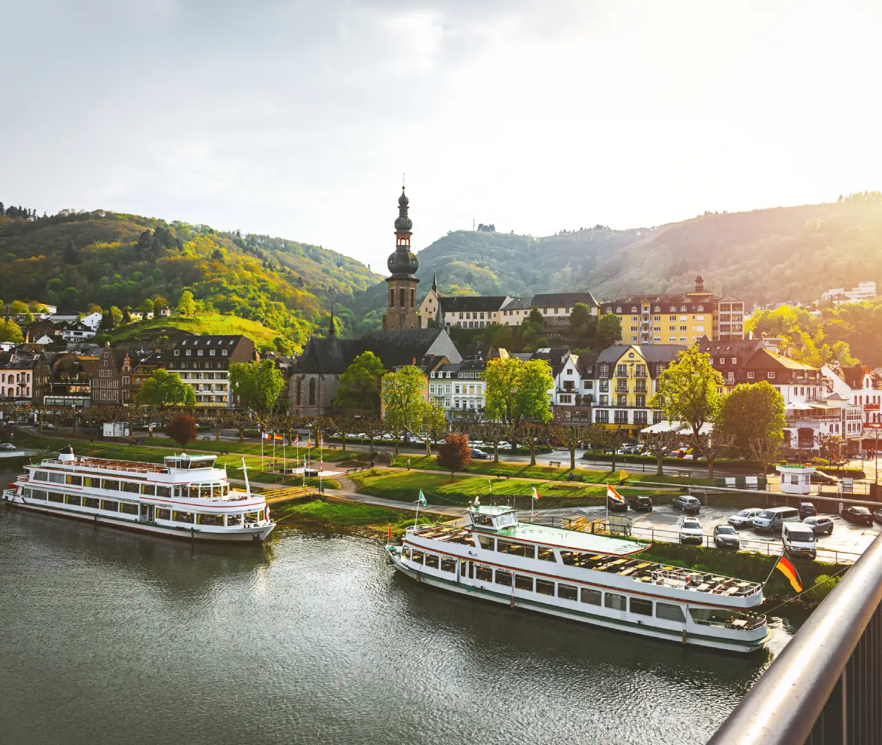 Scenic riverside town with boats and church.