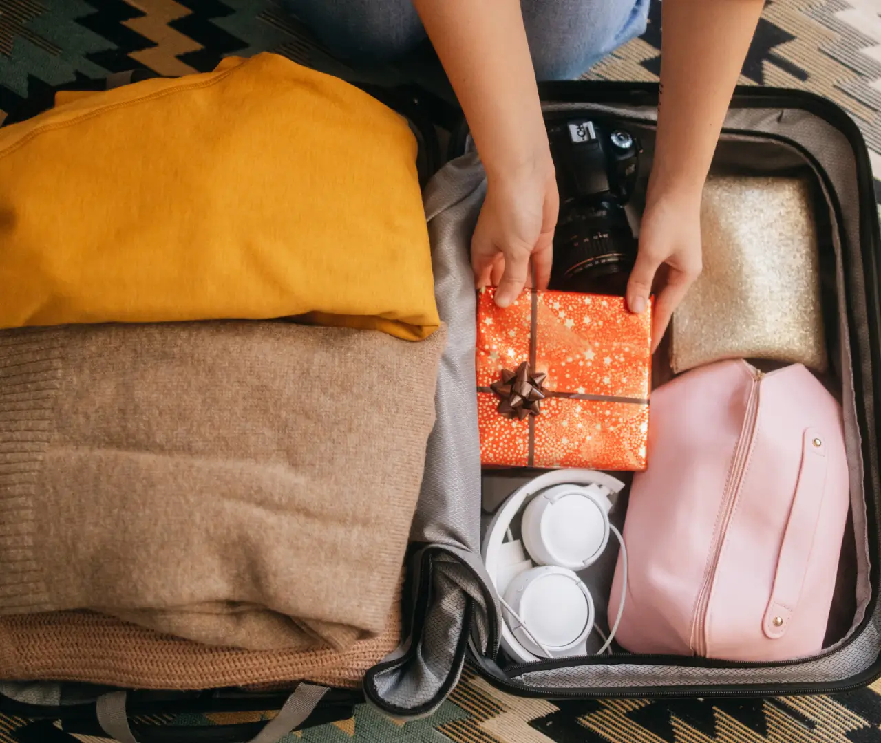 Packing clothes and gifts in suitcase.